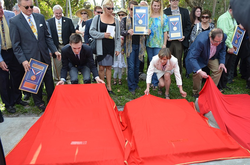 Louis Ducruet, grandson of H.S.H the Prince Rainier III of Monaco, Jacqueline Zerbini and Fred Pfening III prepare to unveil their respective plaques.