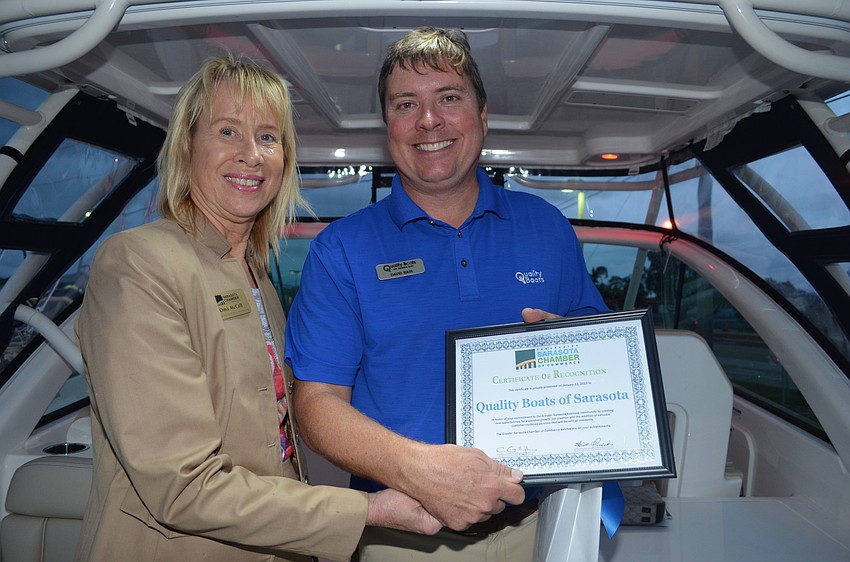 Oma McCall presents David Bair of Quality Boats with a certificate of recognition at the Monday Mixer Jan. 12.