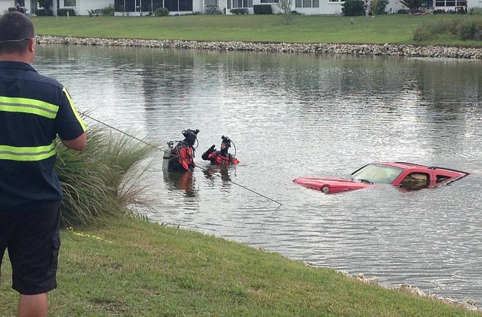 (Courtesy Sarasota Police Department) Sarasota Police divers help pull a red Jeep Cherokee out of a north Sarasota lake Tuesday.