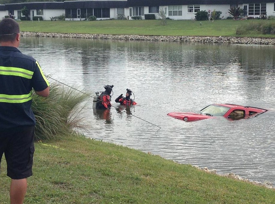 (Courtesy Sarasota Police Department) Sarasota Police divers help pull a red Jeep Cherokee out of a north Sarasota lake Tuesday.