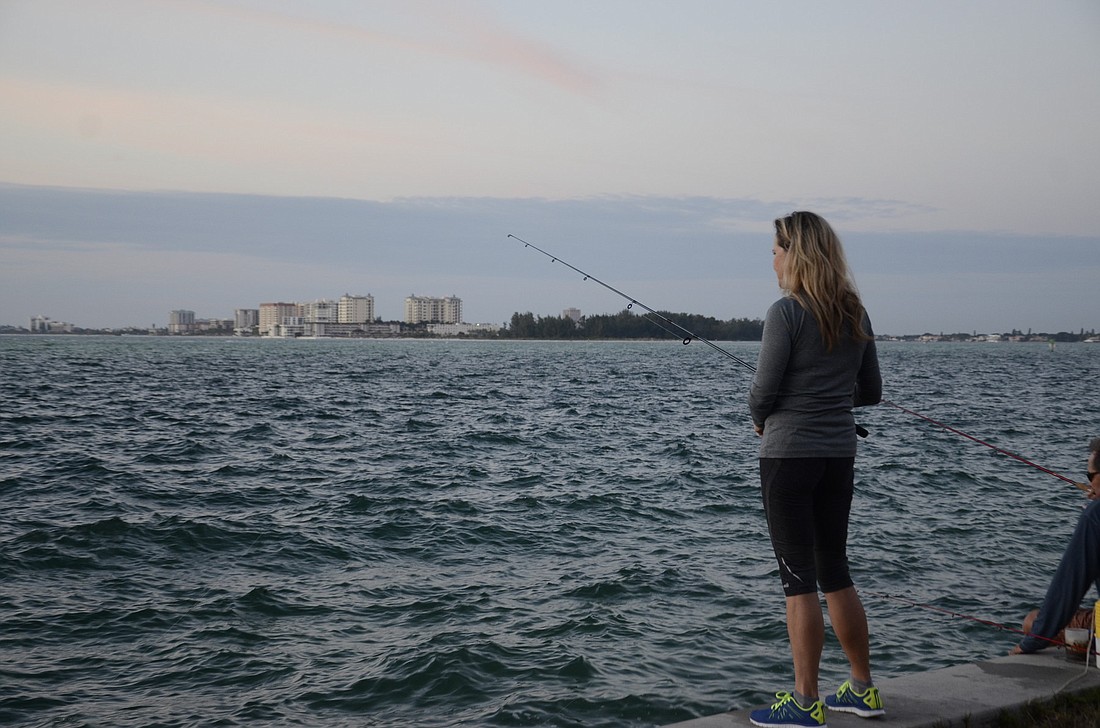 Cindy Kolb fishes at a beach access across from Givens Street on Siesta Key. Lido Key is across Big Pass in the distance.