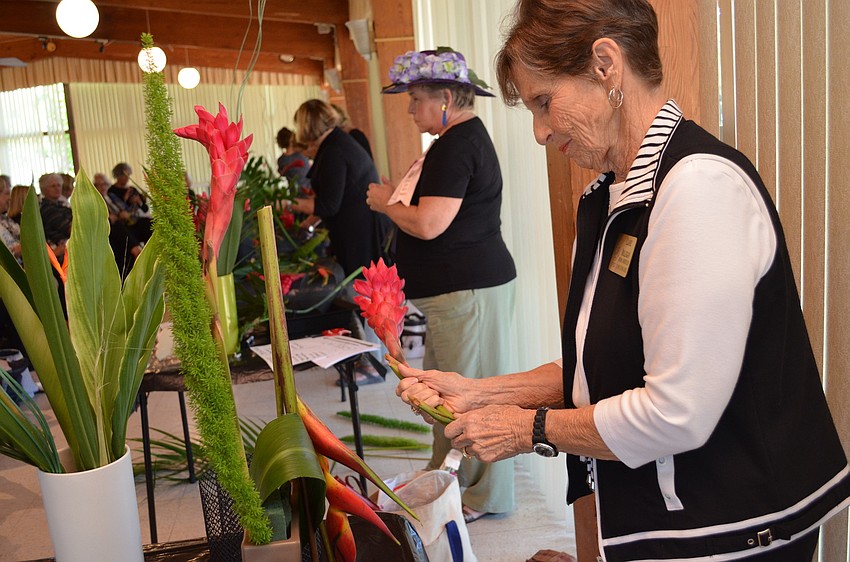 Clare Milligan bends a stock of ginger for her entry for the Sarasota Garden Club Floral Design Challenge.
