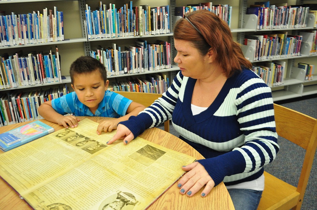 Devin Valadez, a student at Freedom Elementary School, reads a book about Abraham Lincoln with his mother, Kerry, at the Braden River Branch Library. Pam Eubanks