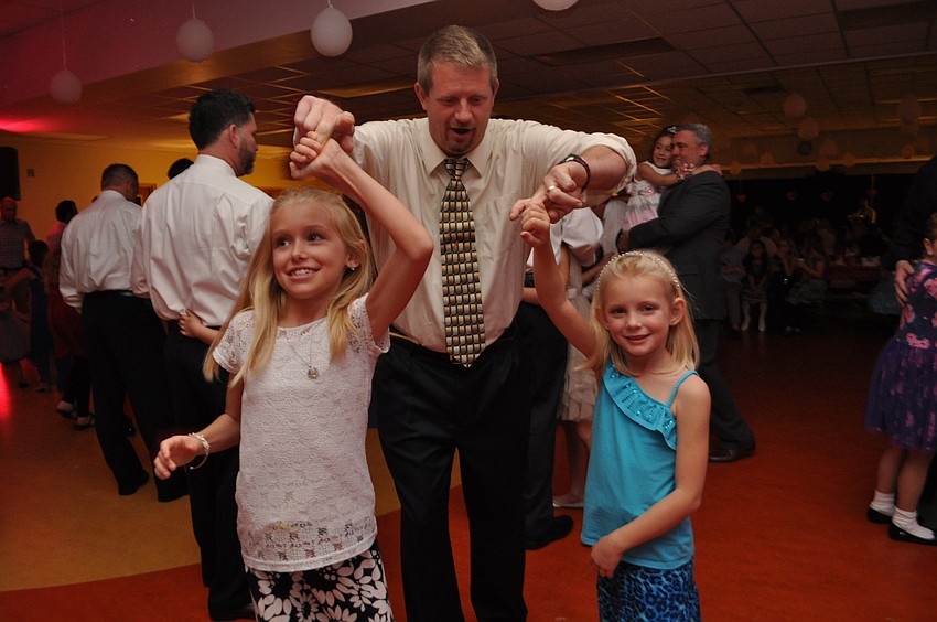 Brad Gemme twirls his daughters, Madilyn, let, and Chelsea, right.
