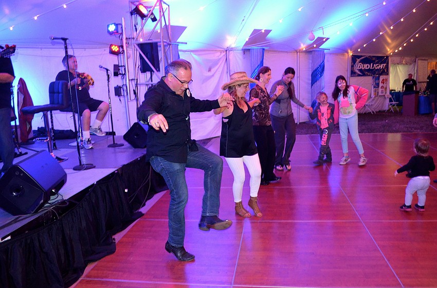 Stamatis Zeris enjoys Greek music, while leading a line of fellow dancers.