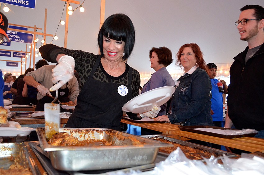 Maria Brady serves up moussaka to patrons.