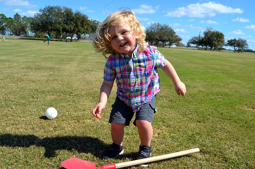Two-year-old John Lane makes his own fun while his parents watch the polo match.