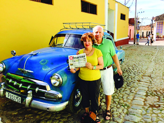 Joni Steinberg and Sandy Rederer brought their Sarasota Observer along on a recent trip to Cuba. Here they are standing next to a 1950s Chevrolet in the town of Trinidad.