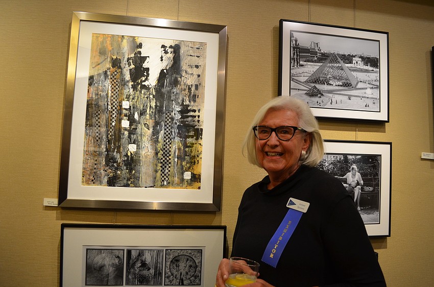 Exhibitor Arlene Sjosten in front of her painting, â€œCity Lifeâ€