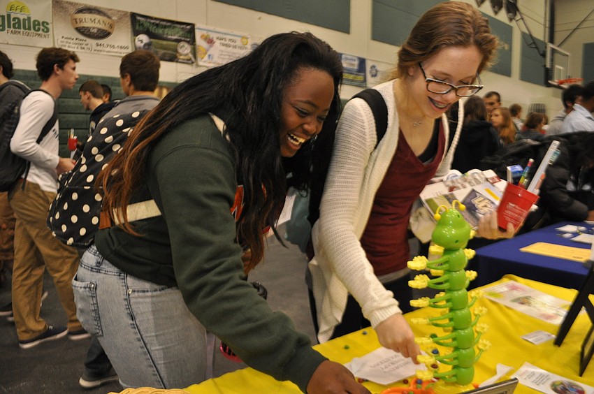 Dorothy Rodriguez and Jamie Newby test their fine motor skills at an occupational therapy booth.