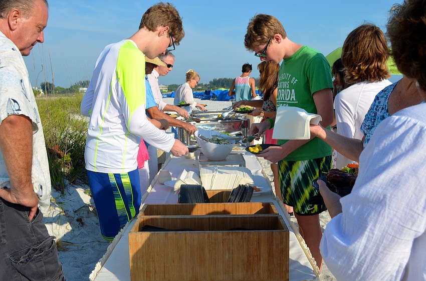 Guests fill their plates with all the barbecue essentials.