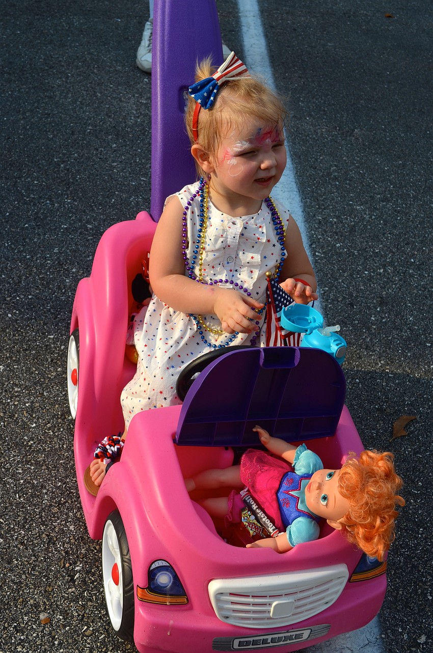 Brynn Shear watches the parade from her pink car.