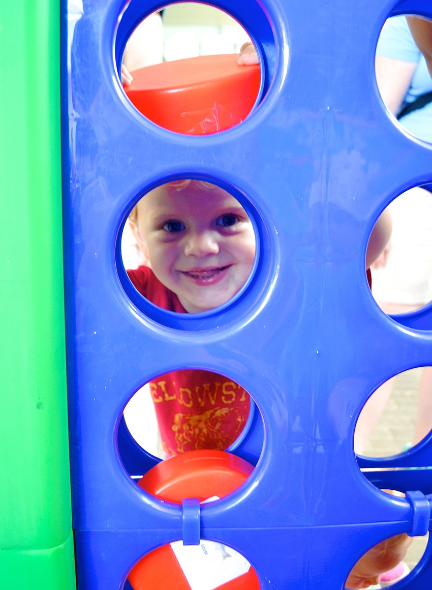 Colin Sellers, 2, smiles as he plays a life-size game of Connect Four.