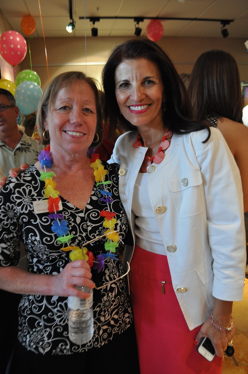 Nancy Erickson, of Arcpoints Labs, greets Violeta Huesman, of Keiser University.