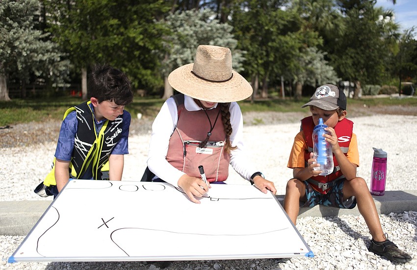 Cooper Kennedy and Alex Berndt watch as Katie Freeley plans the groupâ€™s journey.