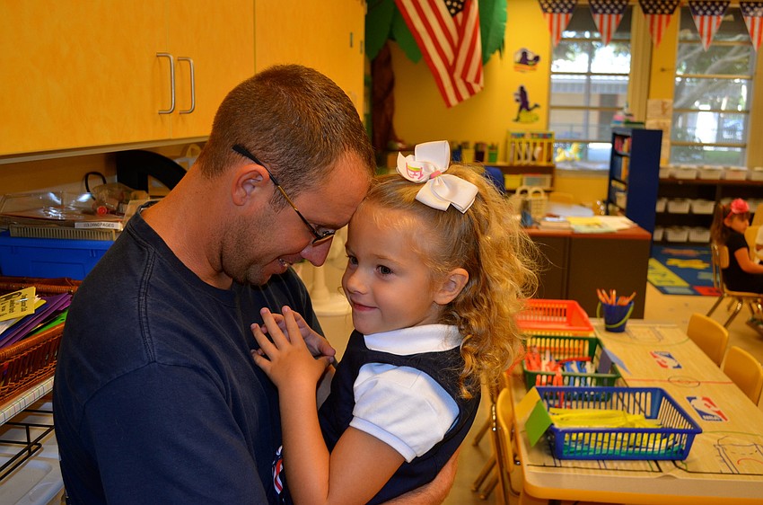 Derek Foss kisses his daughter, Elizabeth, goodbye.