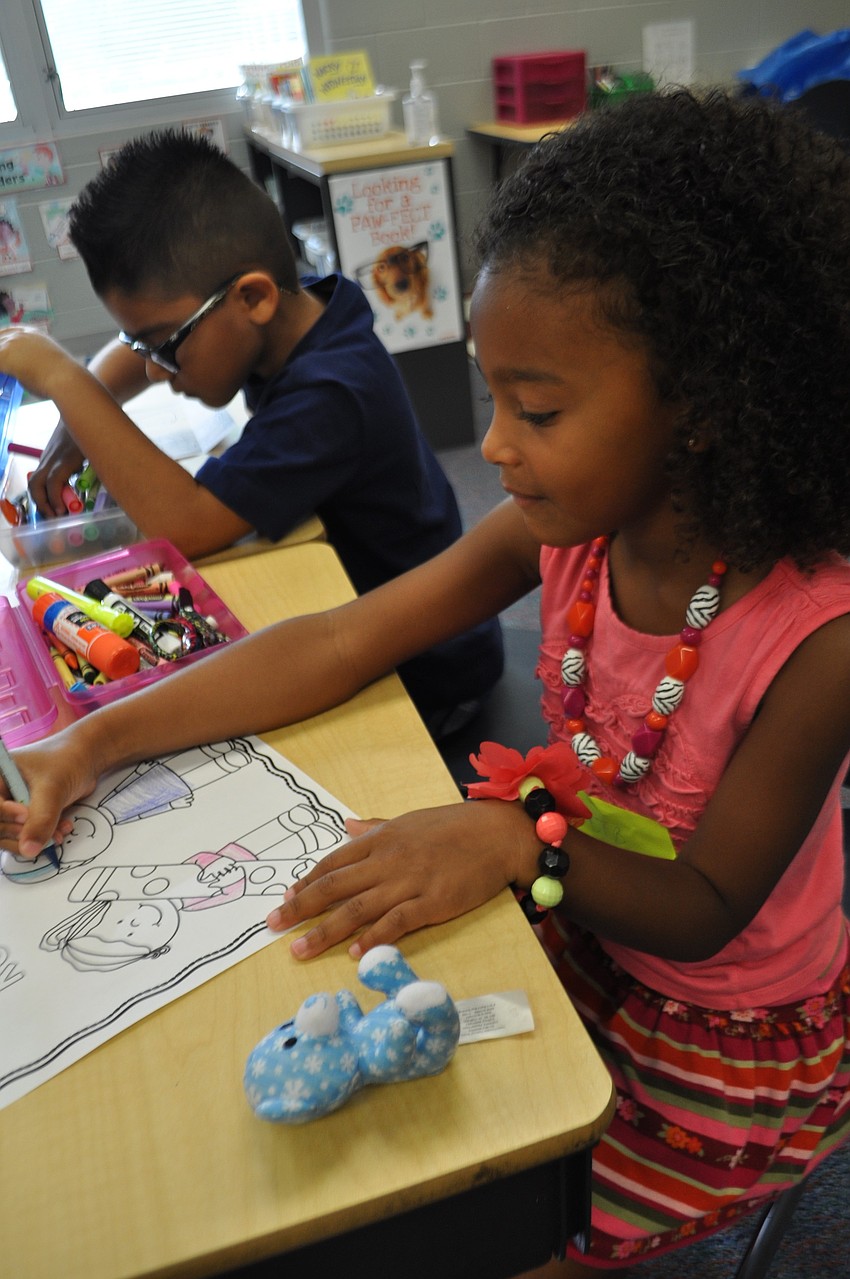 Adele Lomastro, 6, colors once she settles into her classroom.
