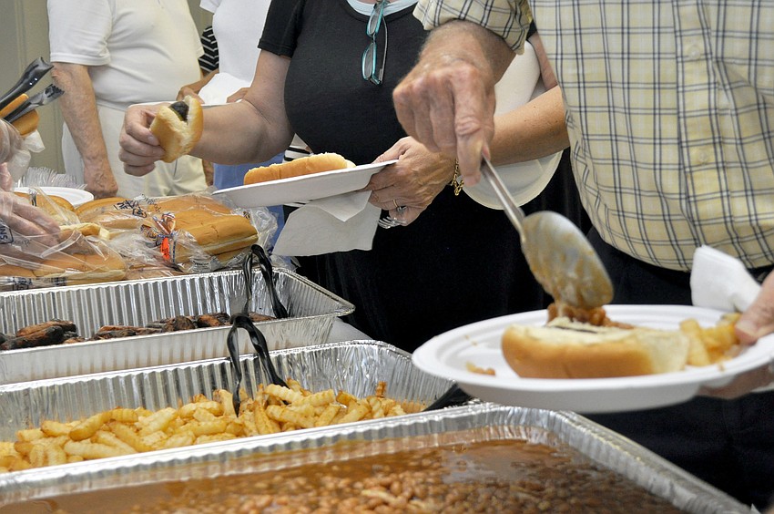 Members and guests fill their plates at the hot dog cookout.