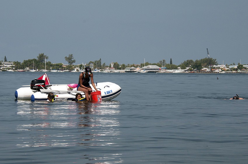A family of volunteers search for scallops.