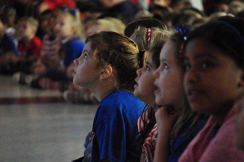 Baylee Hinkle, a second-grader, sings patriotic songs from the front row.