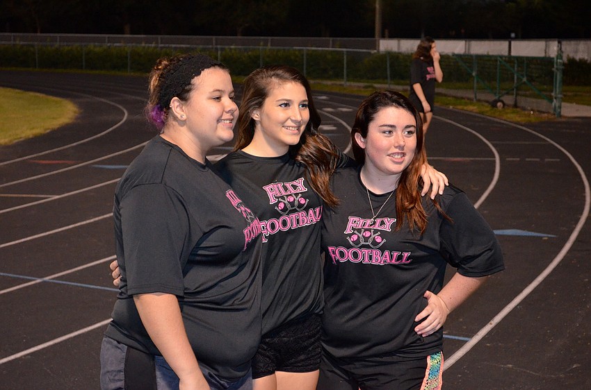 Seniors Natalie Colwell, Kaitlin Mackin and Shaylin Morris pose for photos taken by family members.