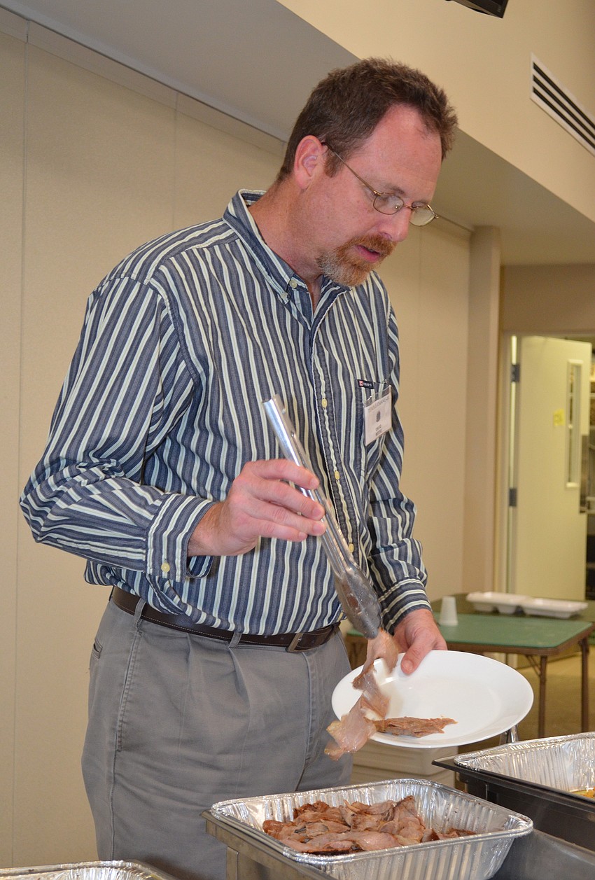 David Meese serves himself brisket.