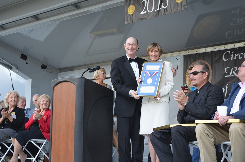 Master of Ceremonies Chuck Sidlow presents Jacqueline Zerbini with a plaque.
