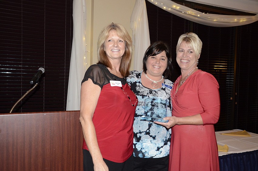 Alana Tomasso, middle, presented Hope Kinney, left, and Sheri Penxa, right, with the Small Business of the Year Award for Painting with a Twist.