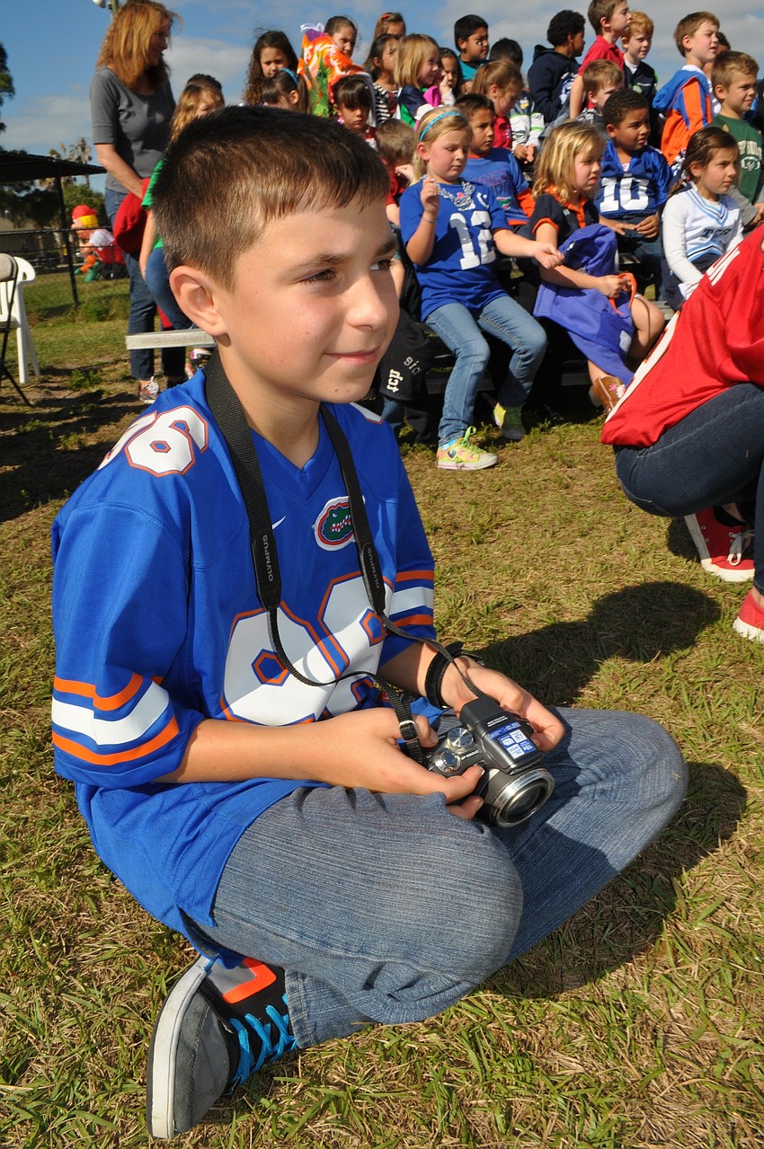 Valeriy Serebryanskiy, 12, takes pictures for the school newspaper.