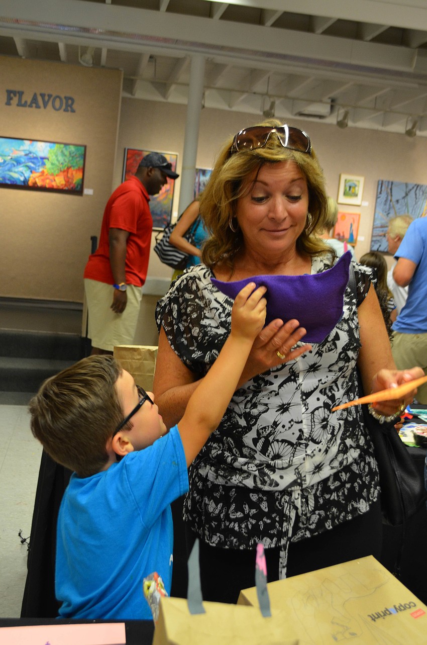 Holden MacDonald shows his grandma Joyce Goldstein his pillow project