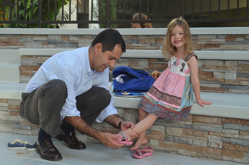 Chris Yancey helps daughter, Juliette, put on her shoes.