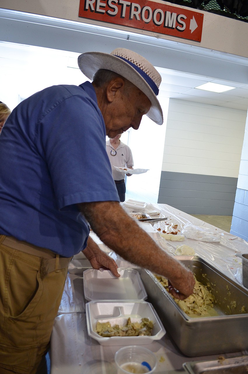 Jim Henry helps serve the Pioneer Day Picnic staple of swamp cabbage.