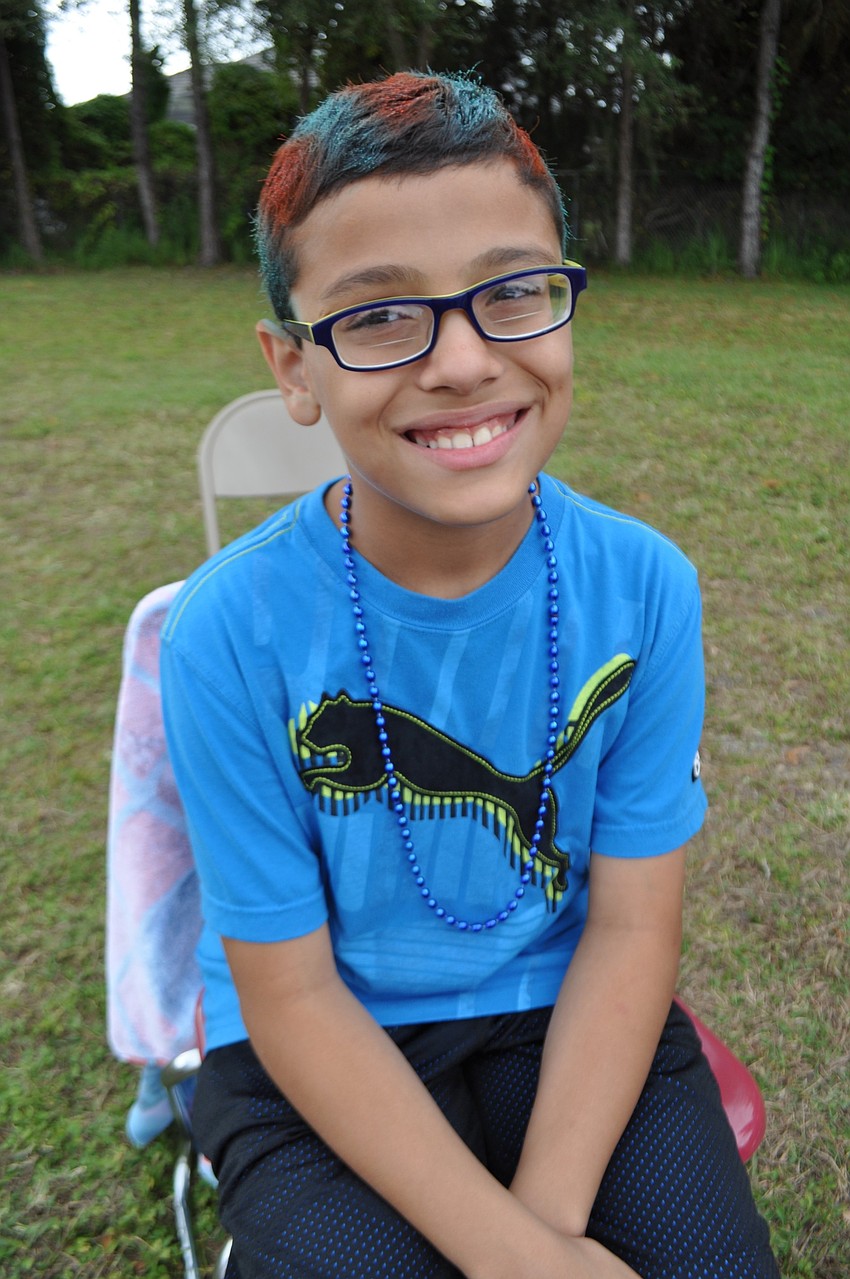 Layth Ghnaim gets his hair colored in orange and blue.