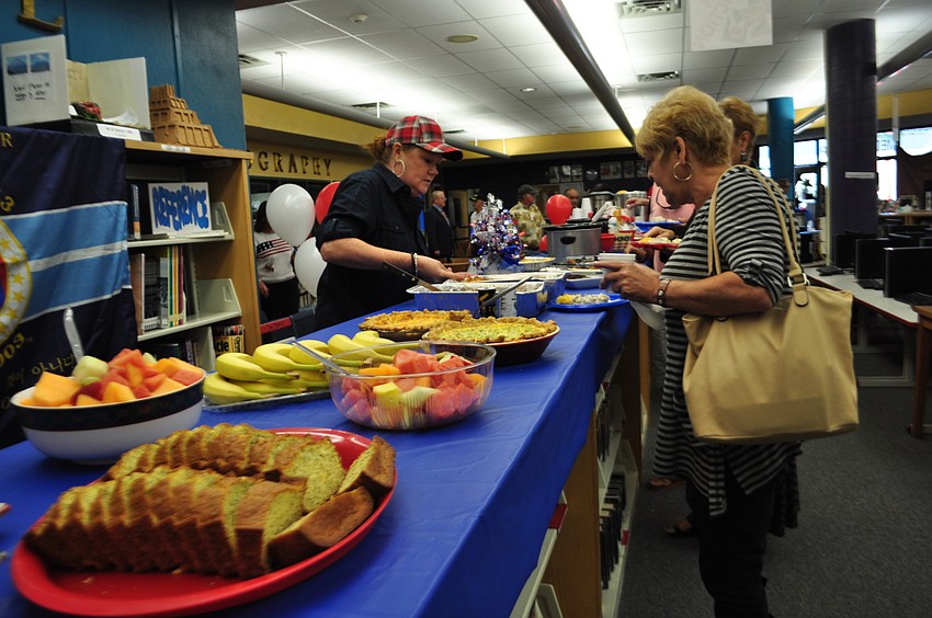 Cindy Martinez, right, selects food during a special breakfast for veterans and guests after the ceremony.
