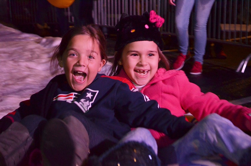 Avery Winslow and Kamaryn Ruck speed down the snow slide.
