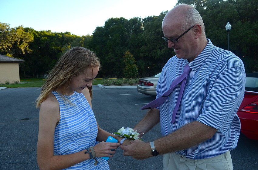 Katie Wilson receives her corsage from her father, Chris.