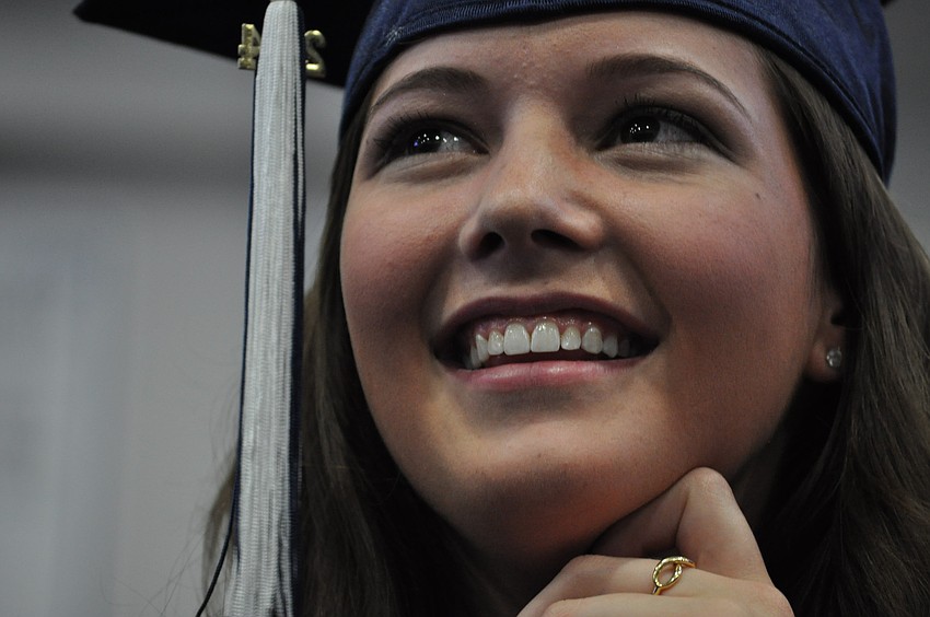 Brenna Correy laughs while listening to the student speaker.