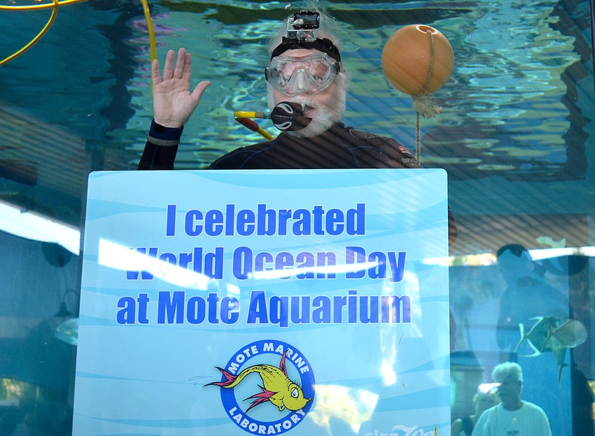 Dr. Michael Crosby, president and CEO of Mote Marine Laboratory, swims in the â€œShark Trackerâ€ exhibit to celebrate World Oceans Day.