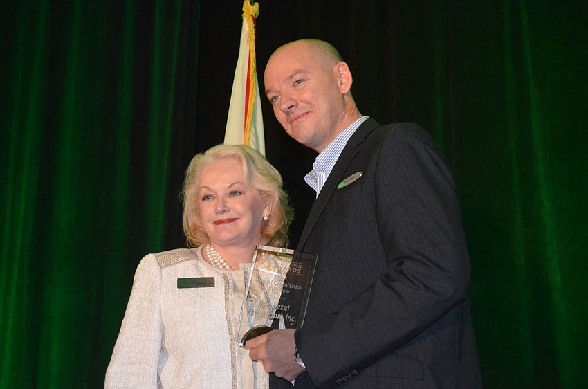 Monica Slater Van Buskirk from the Van Wezel Foundation accepts the Cultural Organization of the Year Award from Rhett Wilson of the Hyatt Regency, Sarasota.