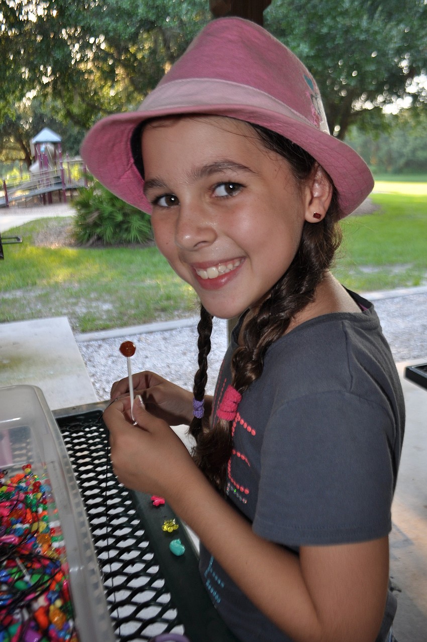 Jenna Link, 8, beads a bracelet.