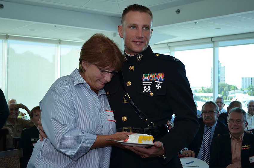 Mary Streppone gives the first slice and a hug to the guest of honor, her son Capt. Geoff Smith.