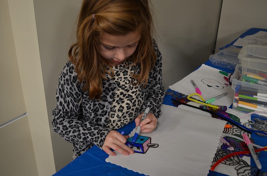 Emma Zoller colors in a dreidel.