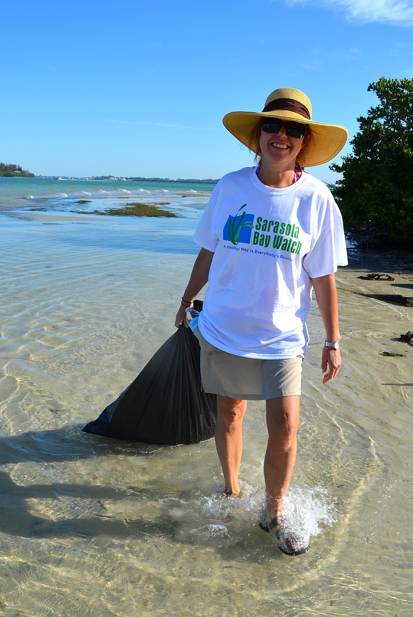 Wanda Raible carries her first bag of trash to the main beach.