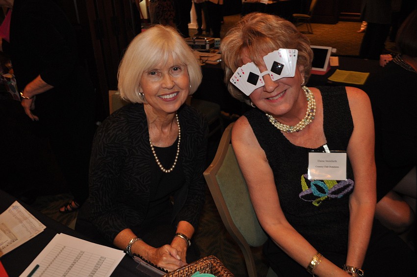 Liz Schreiber and Elaine Steinfurth sell raffle tickets and funny money.