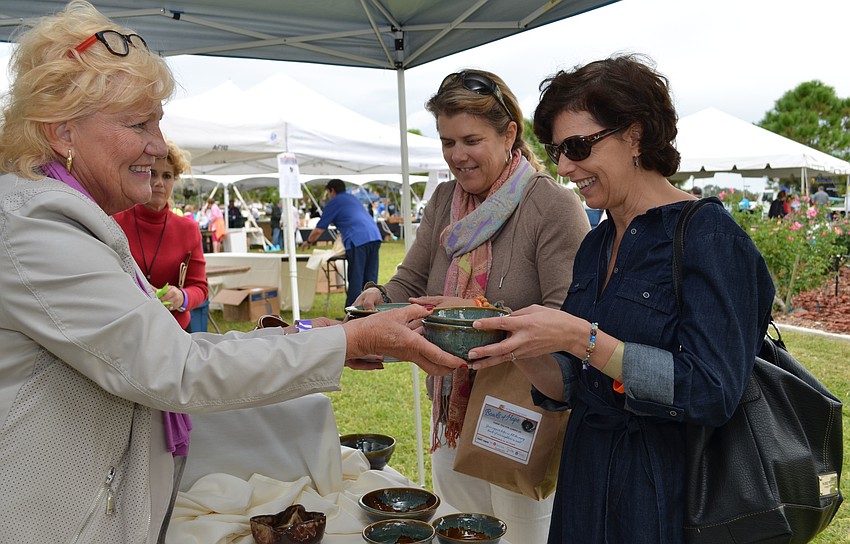 Sandy Lange helps Sue Hecker purchase artisan bowls.
