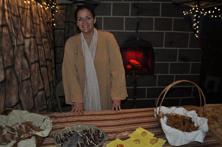 Tori Gross serves stuffed dates, honey cake and other food to guests.