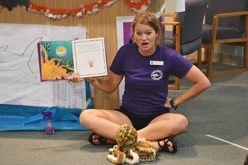 Mandy Wrobel reads to children in the Mommy & Me section of the Night of Fish, Fun and Fright.