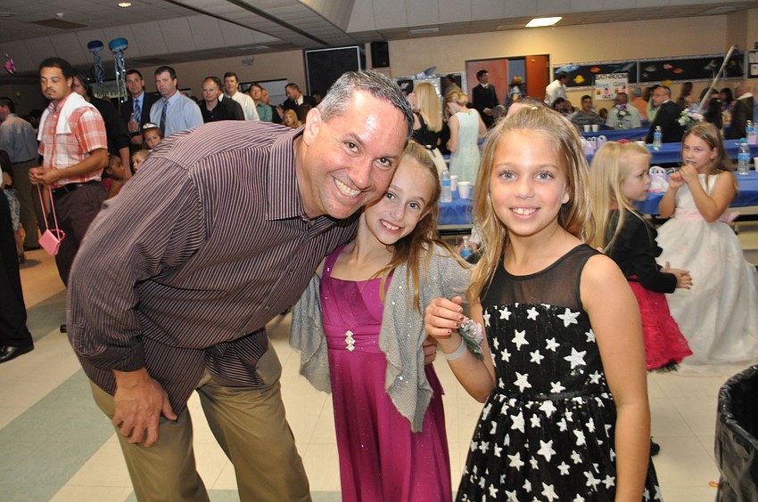 Adam and Corin Mohammadbhoy and Hannah Hastreiter dance the â€œChicken Danceâ€ from the sidelines.