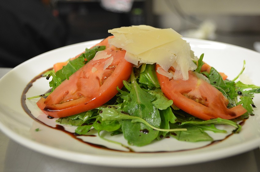 Arugula salad with tomatoes and shaved Parmesan cheese