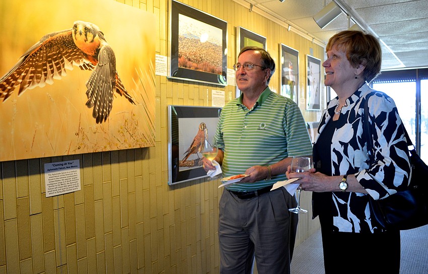 Chris and Janet Narvaez look at Lou Newmanâ€™s photographs during the reception.